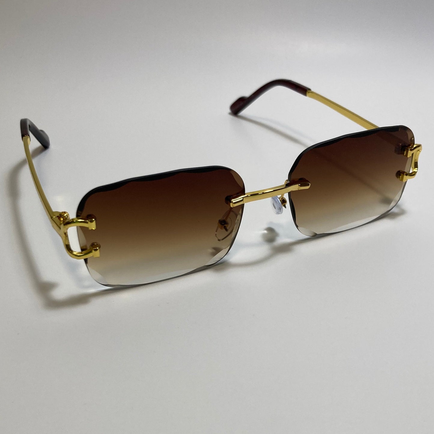 unisex brown and gold rimless oval sunglasses