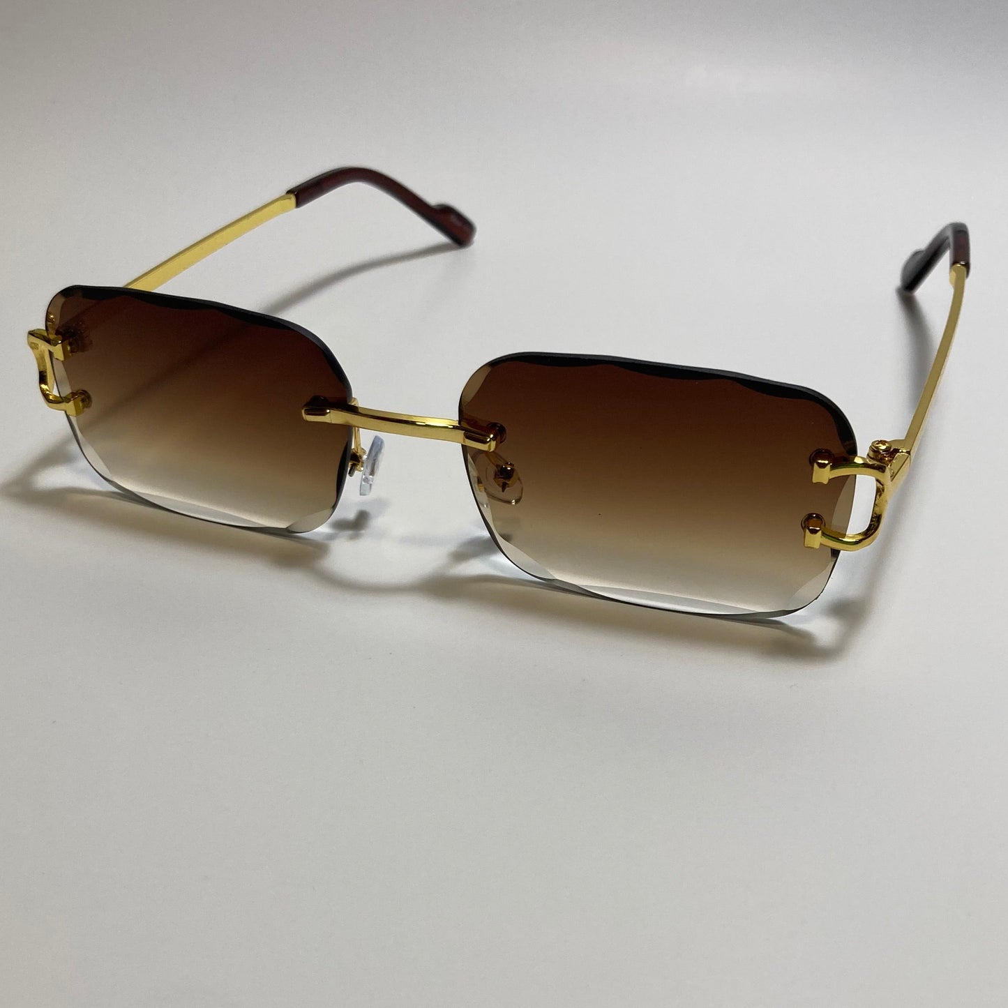 unisex brown and gold rimless oval sunglasses