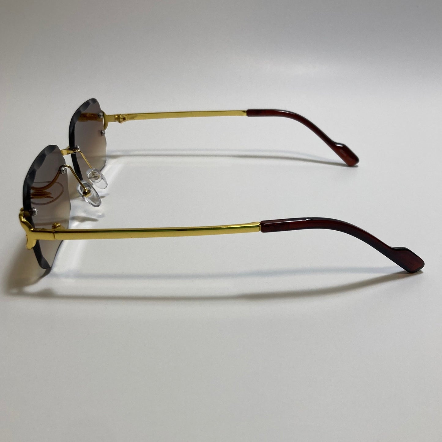 unisex brown and gold rimless oval sunglasses