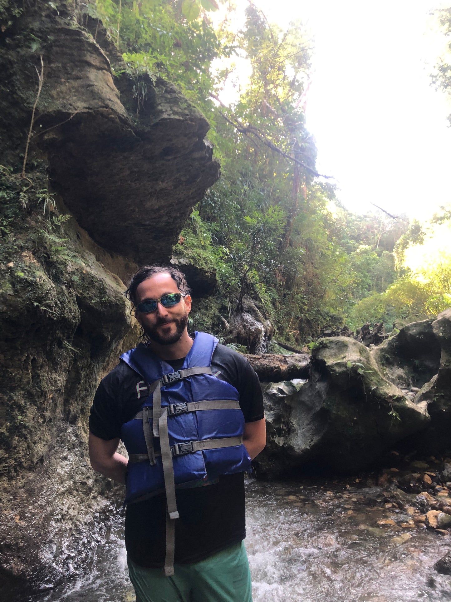 man in tropical jungle wearing mirrored wrap around sunglasses