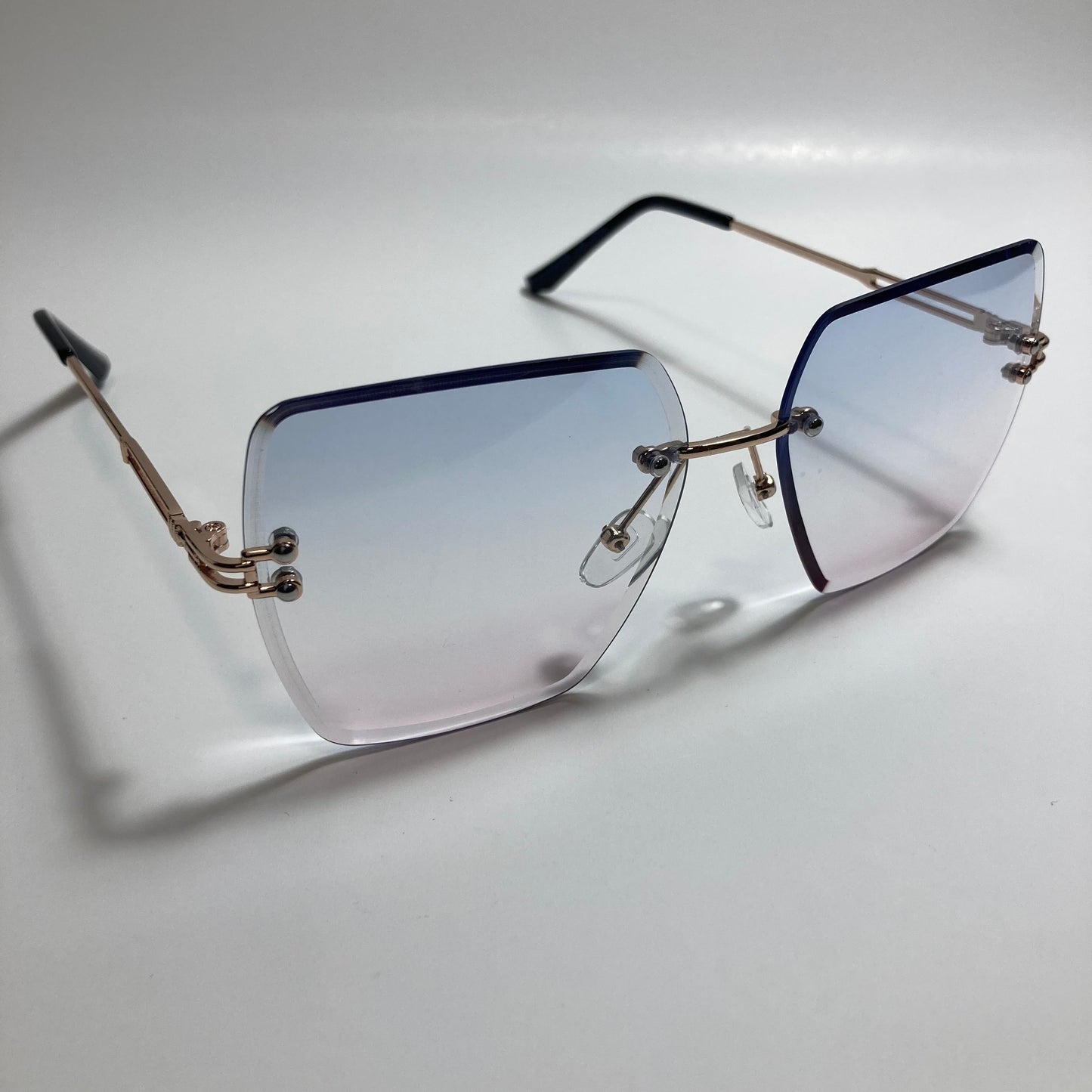 womens blue pink and gold rimless oversize sunglasses