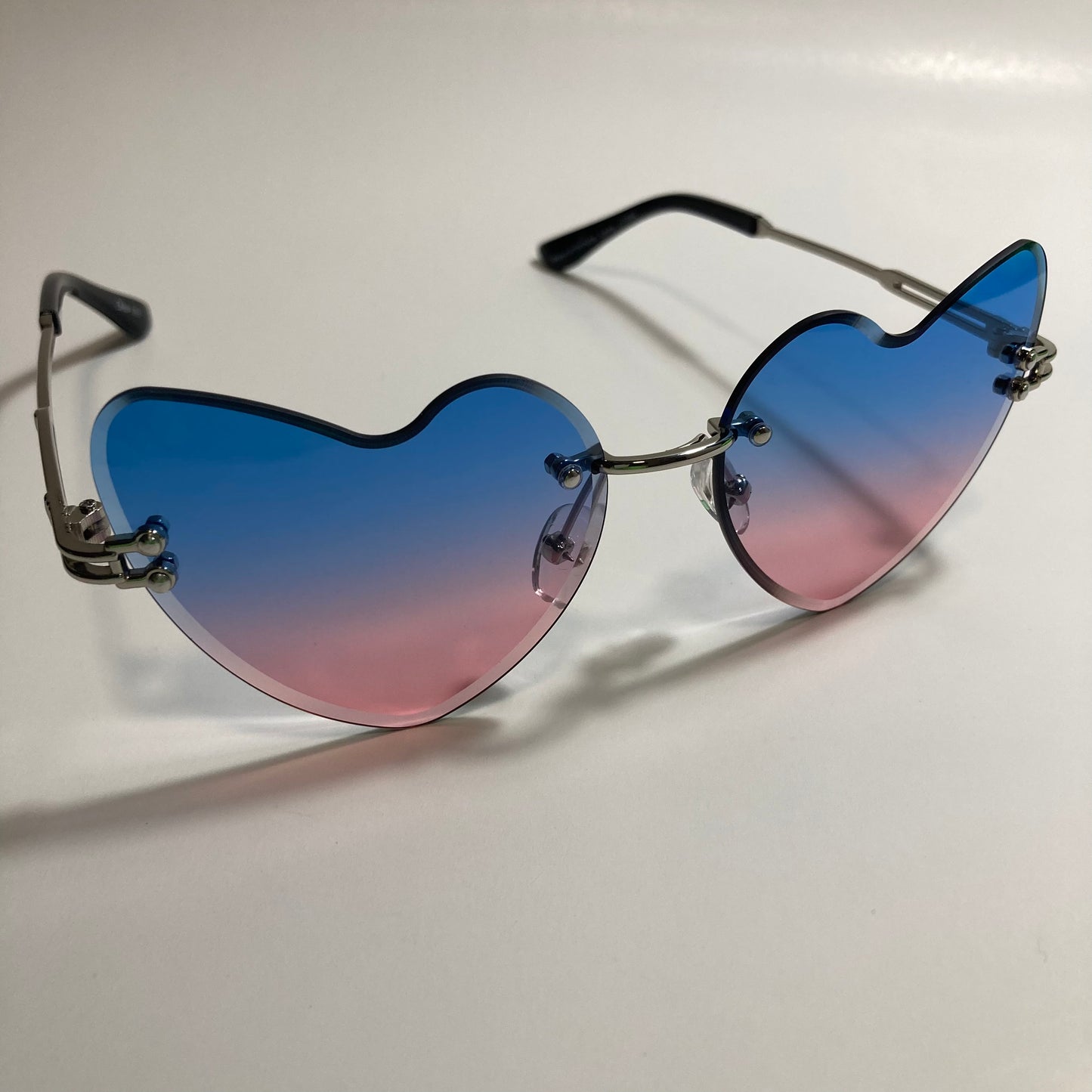 silver womens rimless heart shape sunglasses with blue and pink lenses