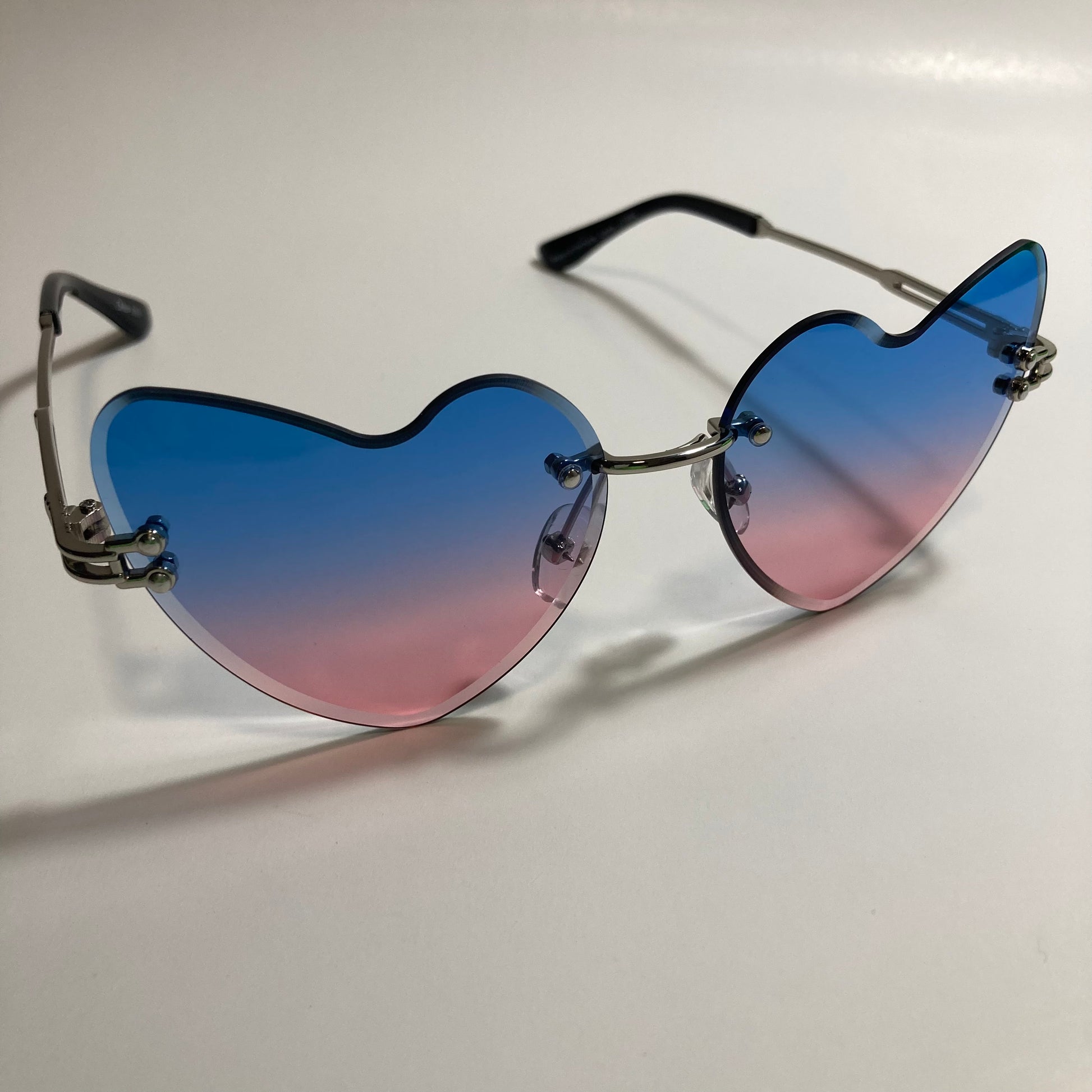 silver womens rimless heart shape sunglasses with blue and pink lenses