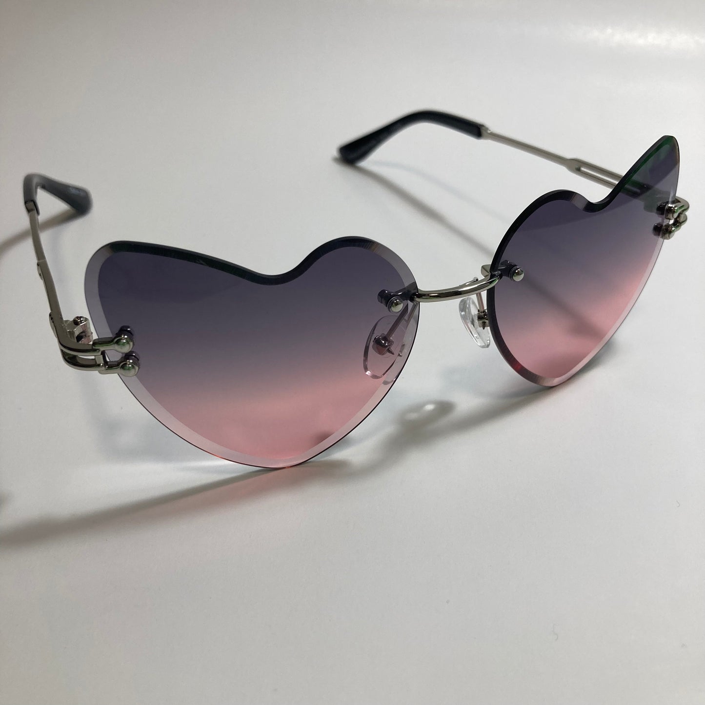 silver womens rimless heart shape sunglasses with black and pink lenses