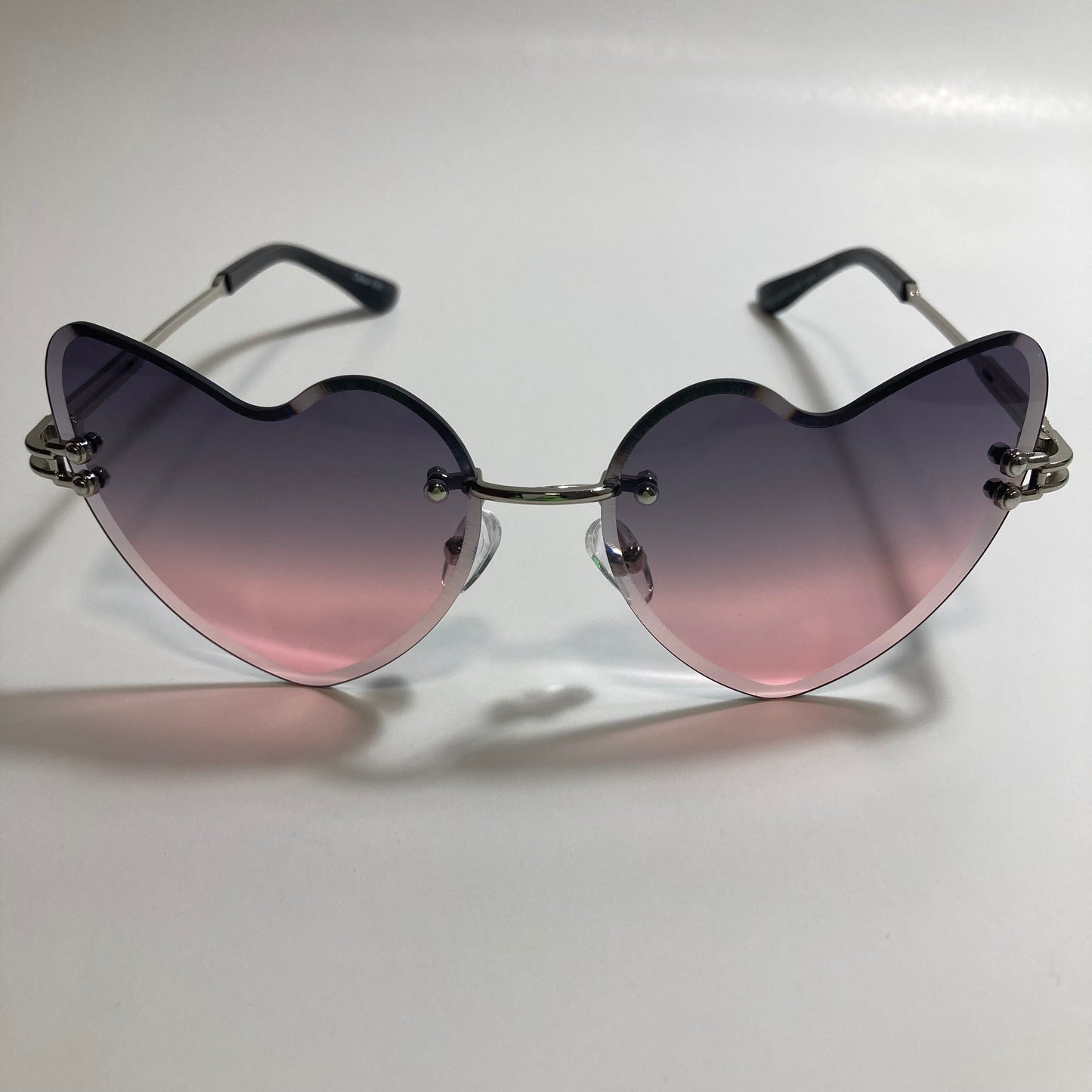 silver womens rimless heart shape sunglasses with black and pink lenses