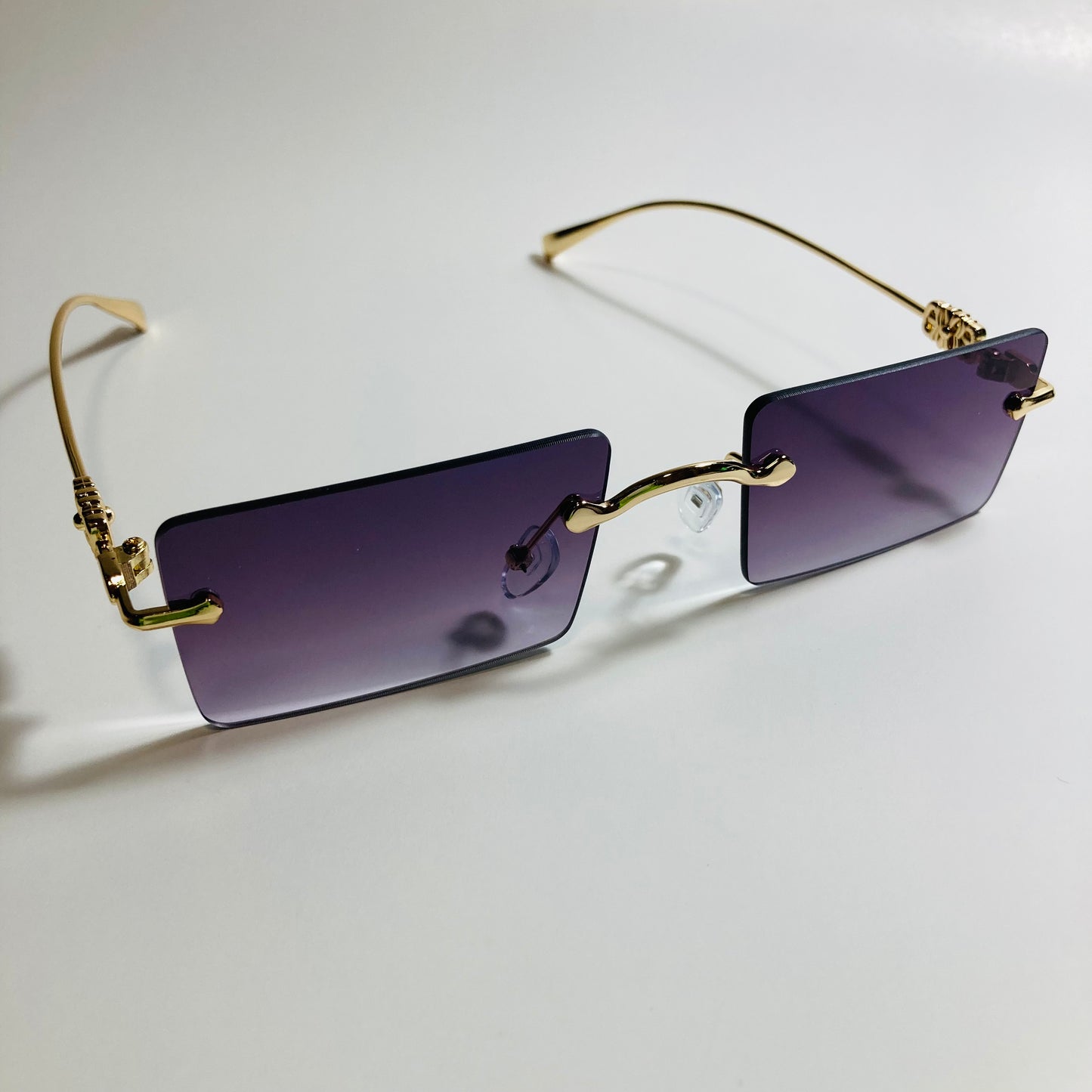 gold rimless womens sunglasses with black lenses and flower accent