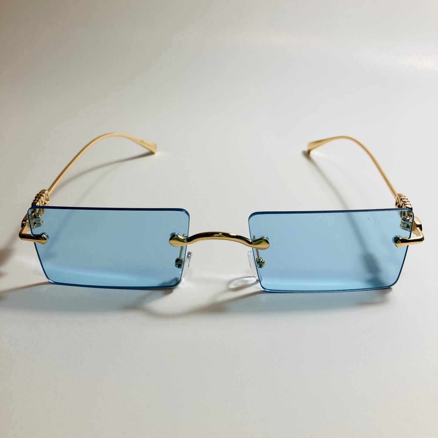 gold rimless womens sunglasses with blue lenses and flower accent