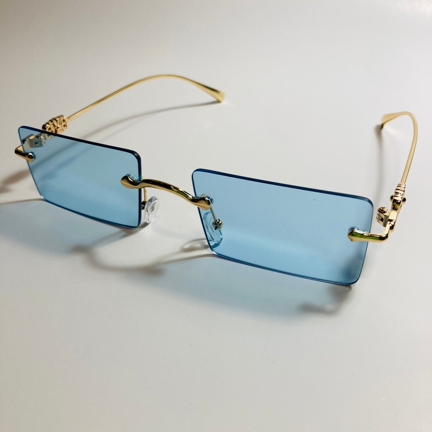 gold rimless womens sunglasses with blue lenses and flower accent