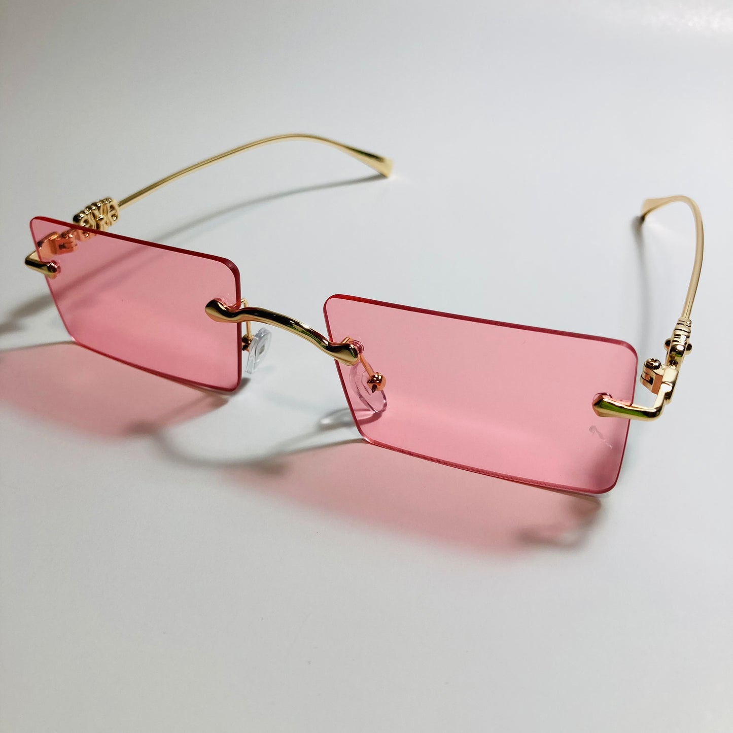 gold rimless womens sunglasses with pink lenses and flower accent