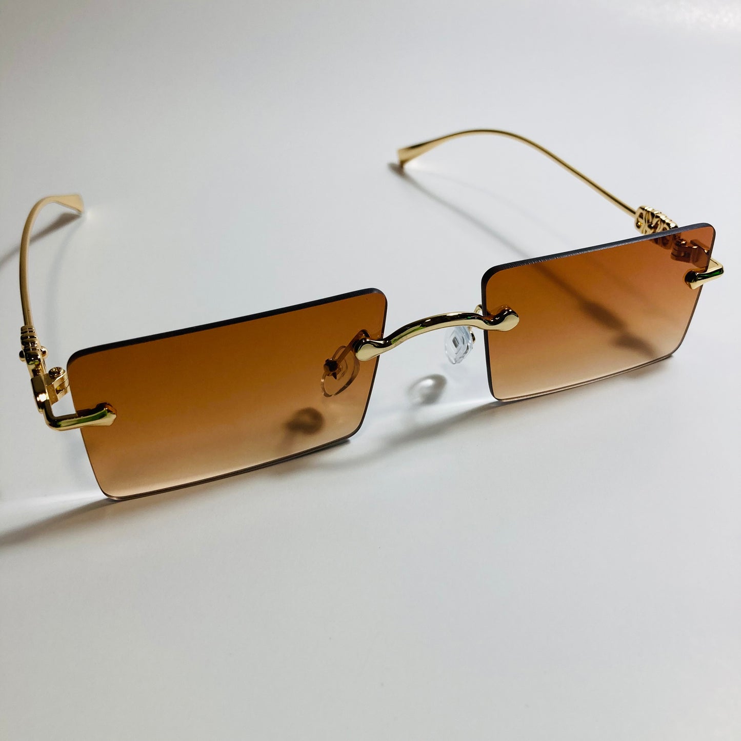 gold rimless womens sunglasses with brown lenses and flower accent