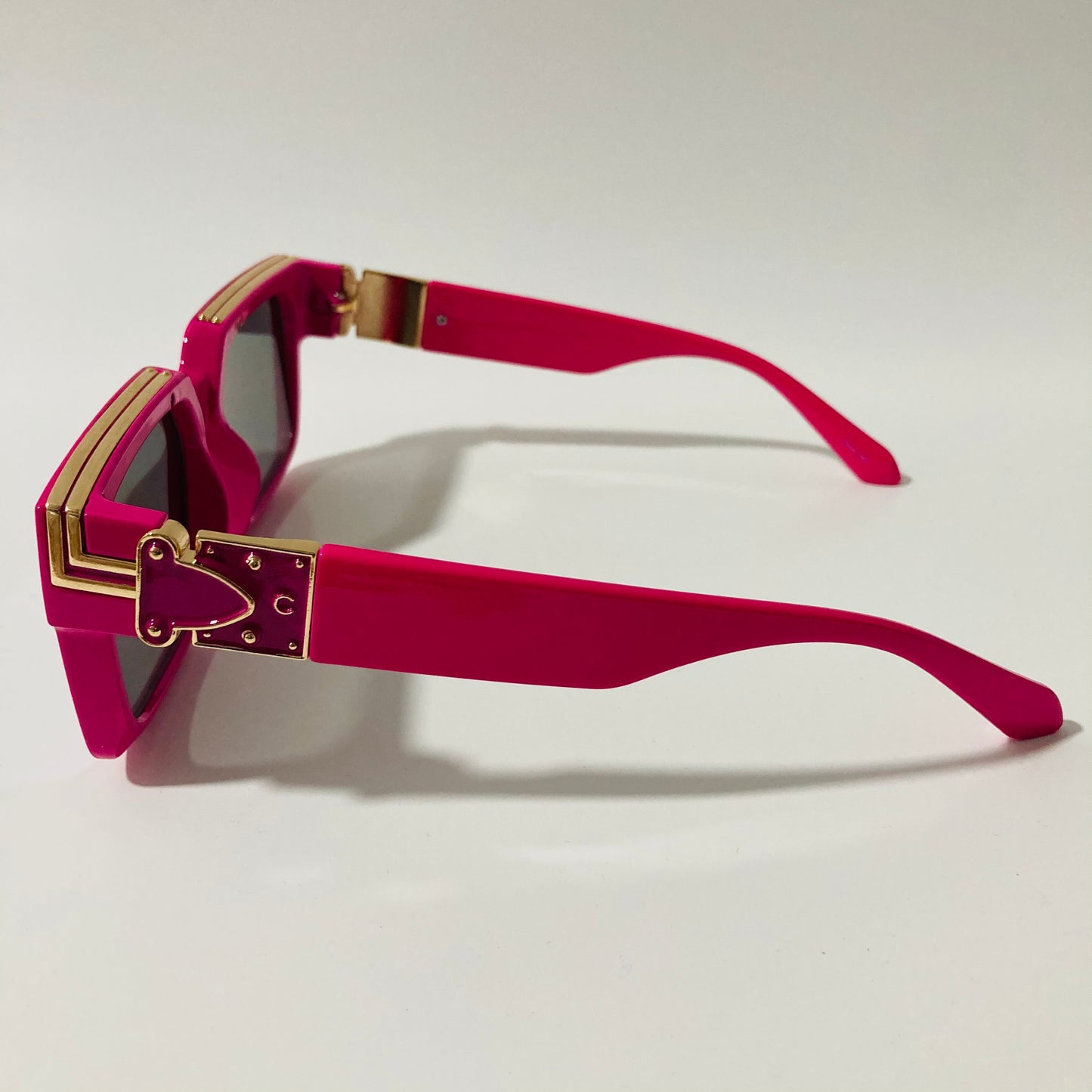 mens and womens pink and black square sunglasses with gold accents