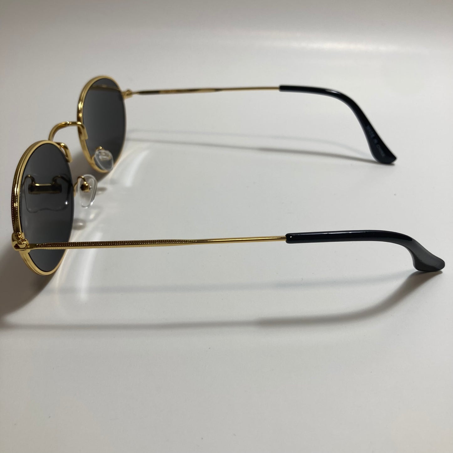 mens and womens small gold round sunglasses with black lenses