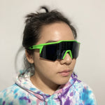 woman wearing green and black wrap around sunglasses